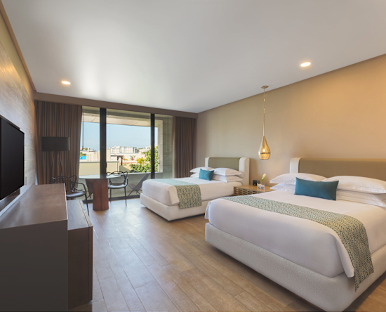 Habitación con camas dobles, sillas y mesa en la esquina de la habitación